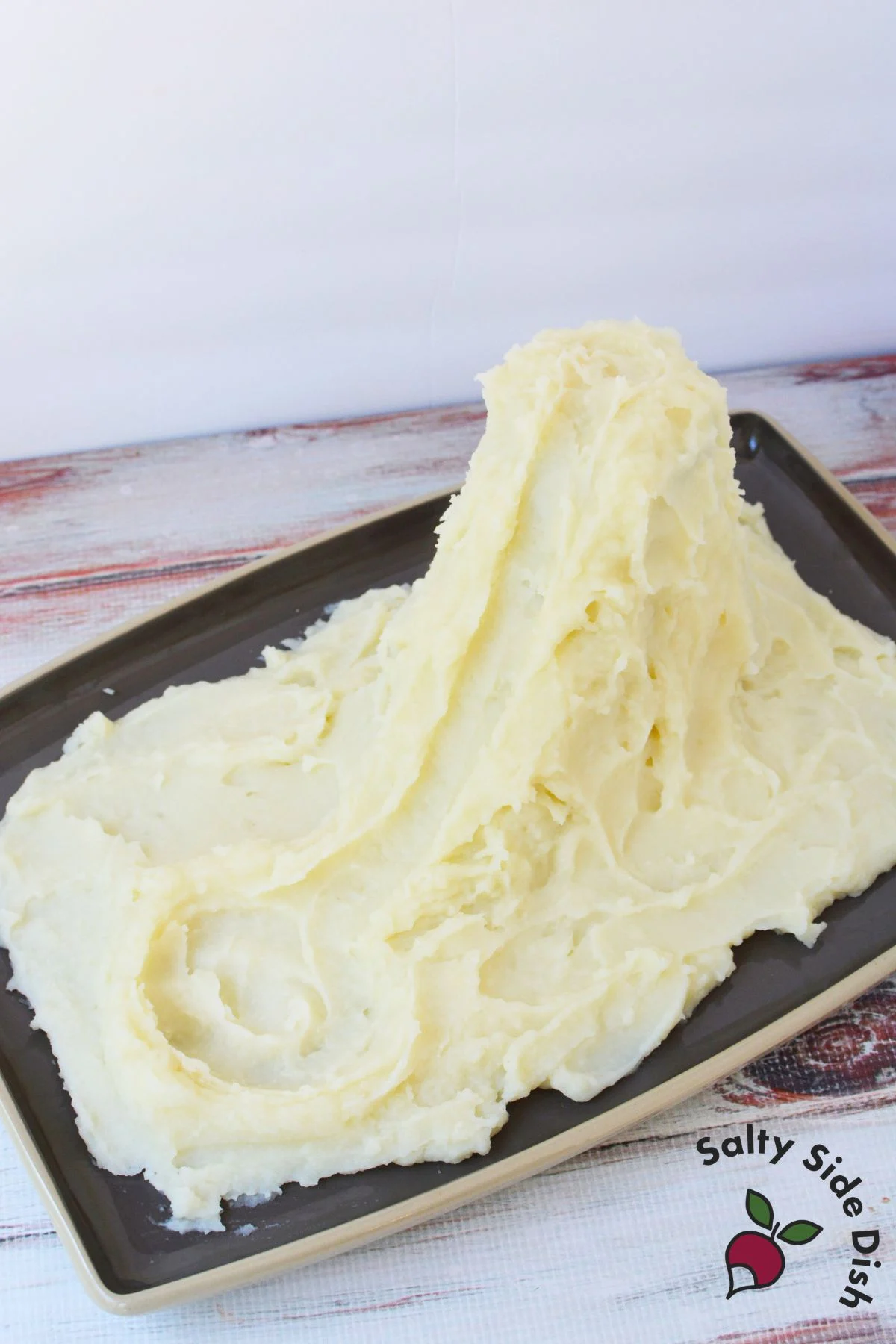 Plain mashed potato mountain shaped on a platter before adding dino nuggets and broccoli