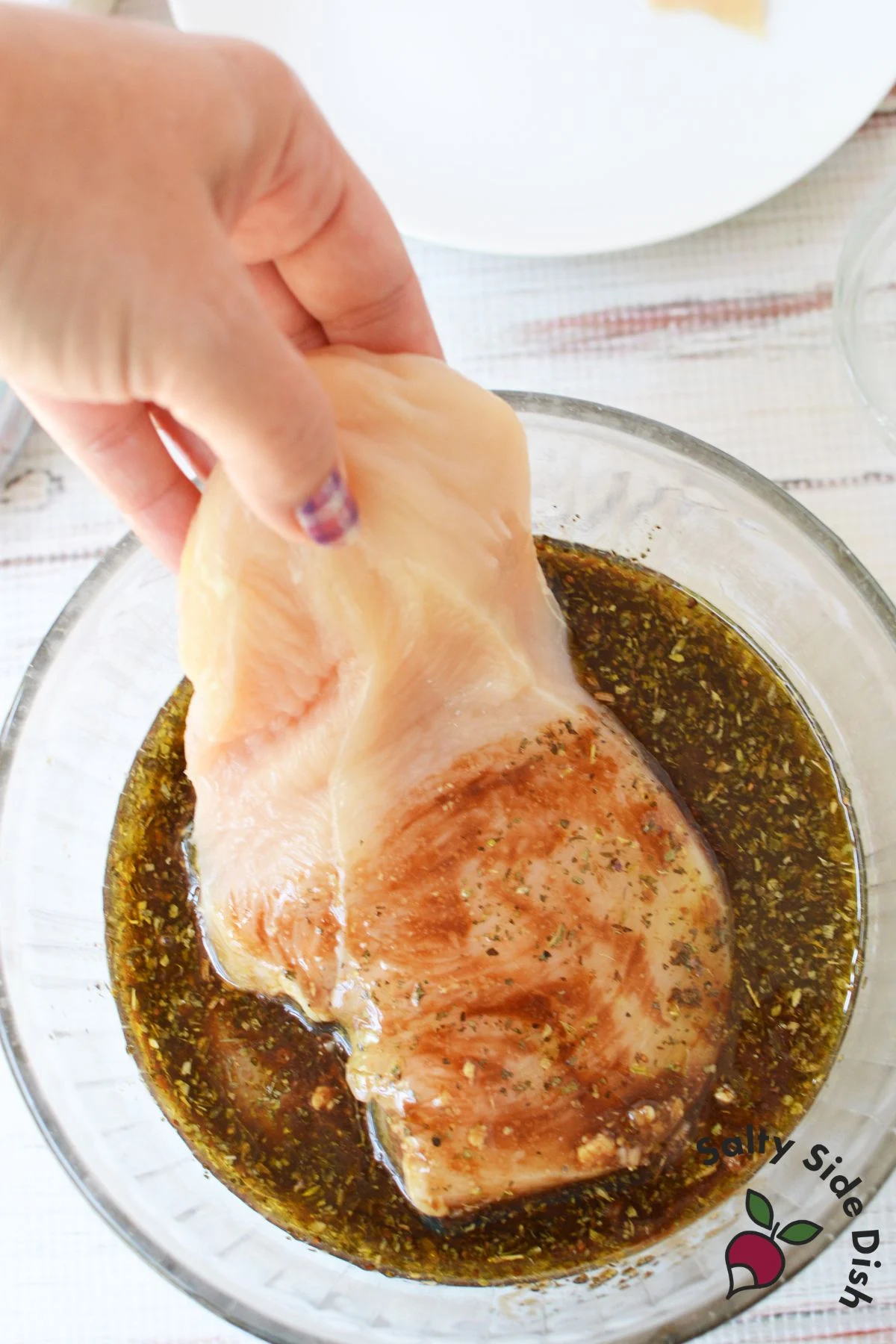 Raw chicken breast dipped into balsamic herb marinade