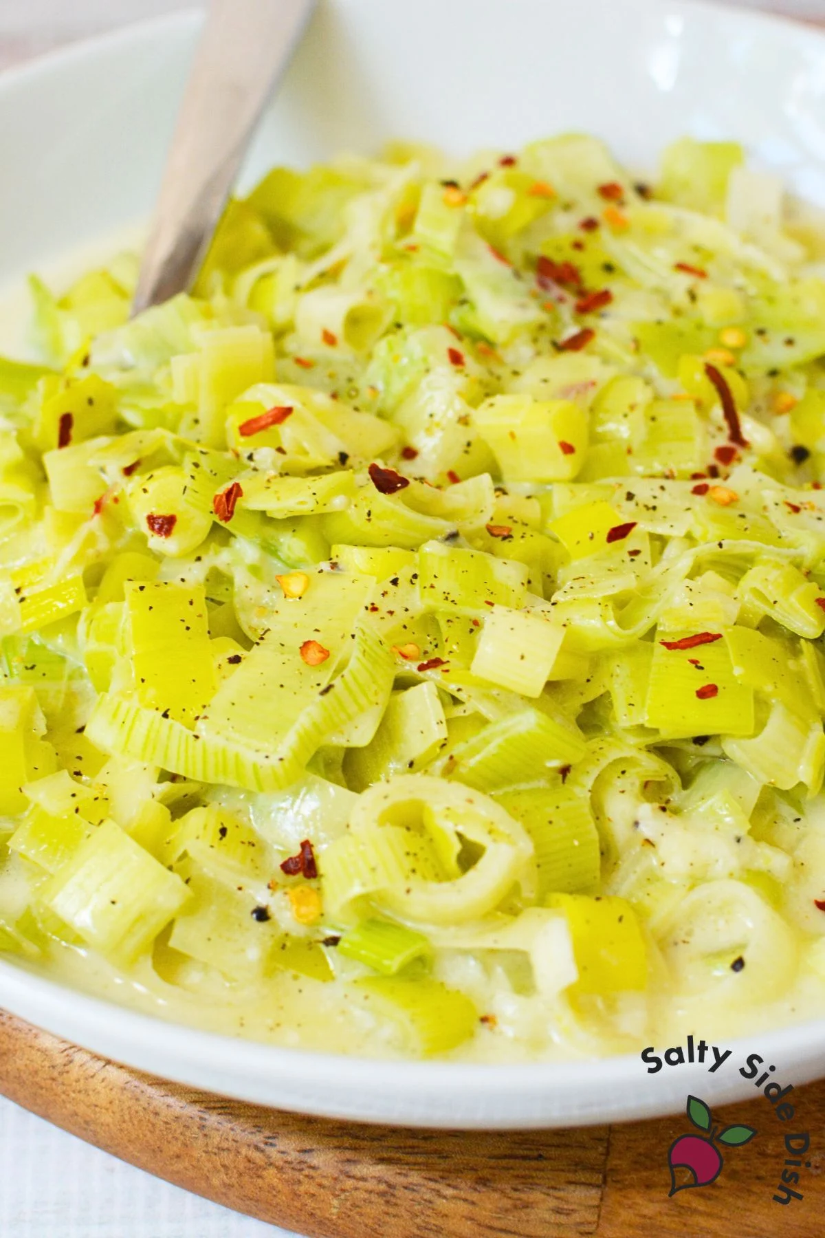 Close up of creamy leeks with parmesan sauce and red pepper flakes