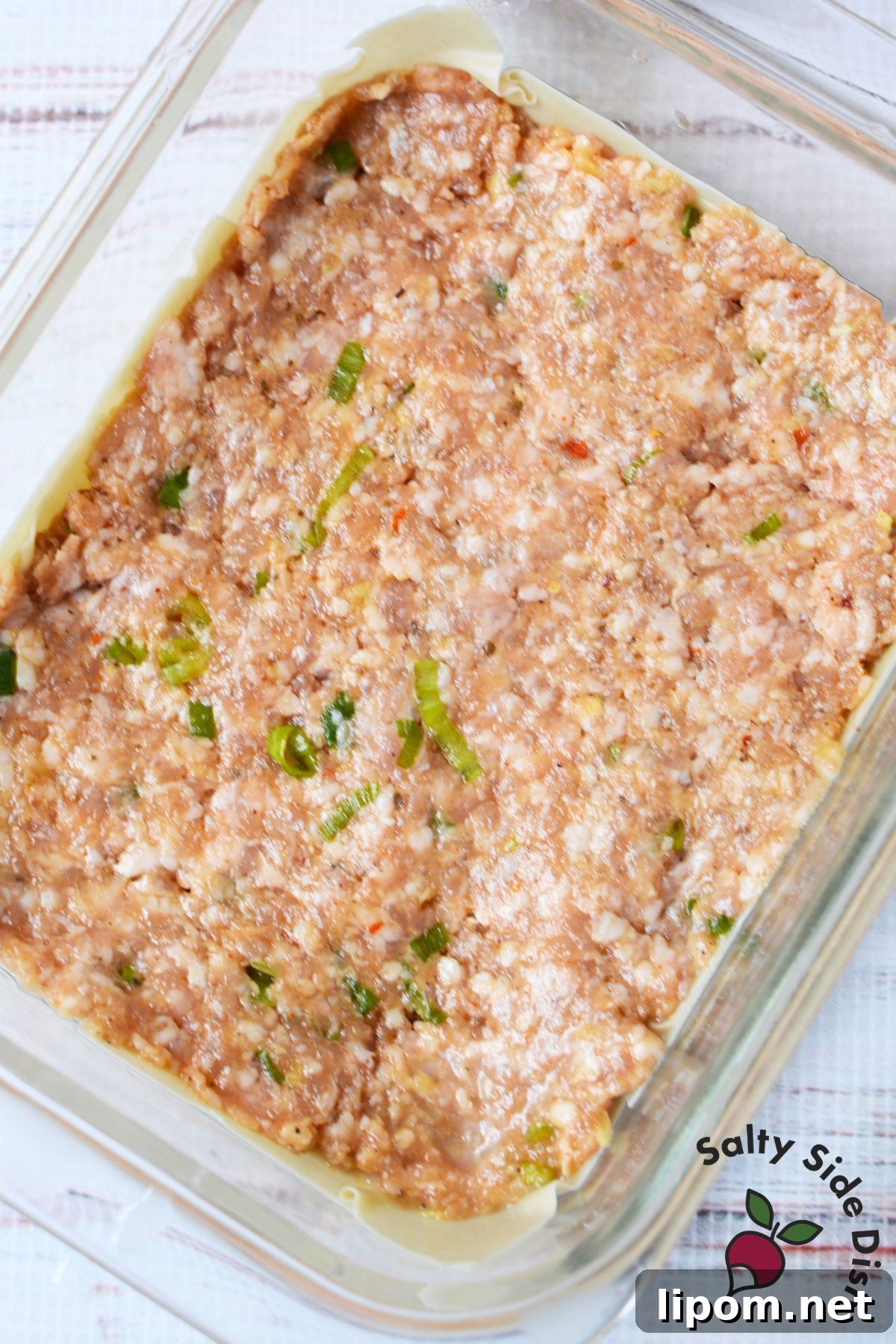 Cheesy Dumpling Lasagna Casserole with Pork and Scallions 6 Seasoned ground pork filling spread over wonton wrappers for dumpling lasagna.