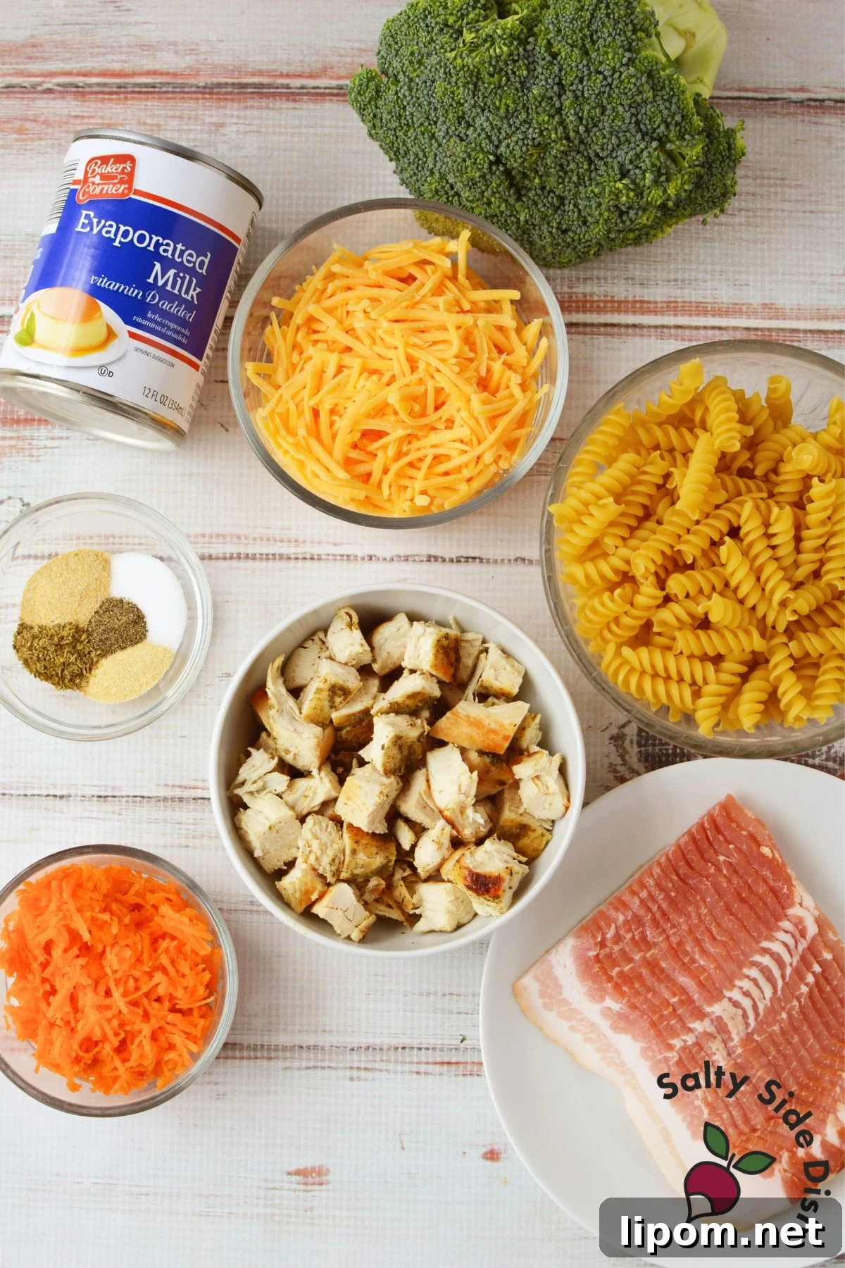 Creamy Chicken, Bacon and Broccoli Pasta with Cheese 3 Ingredients for broccoli cheese chicken pasta, including chicken, bacon, broccoli, carrots, rotini, cheddar cheese, evaporated milk, and seasonings.