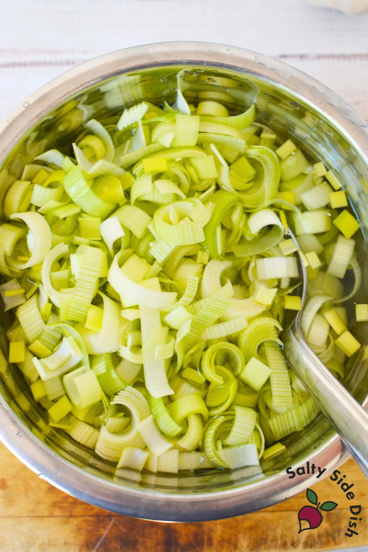 Chopped leeks soaking in a bowl of cold water to remove sand and dirt