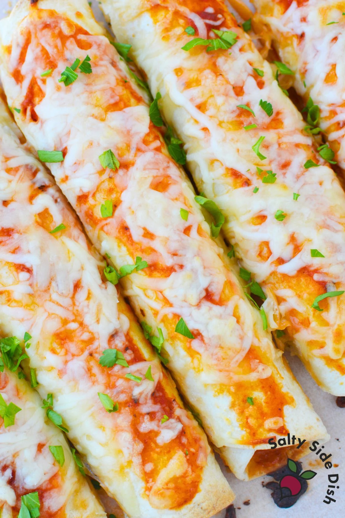 Easy lasagna rolls with tortillas topped with pasta sauce, melted mozzarella, and fresh parsley