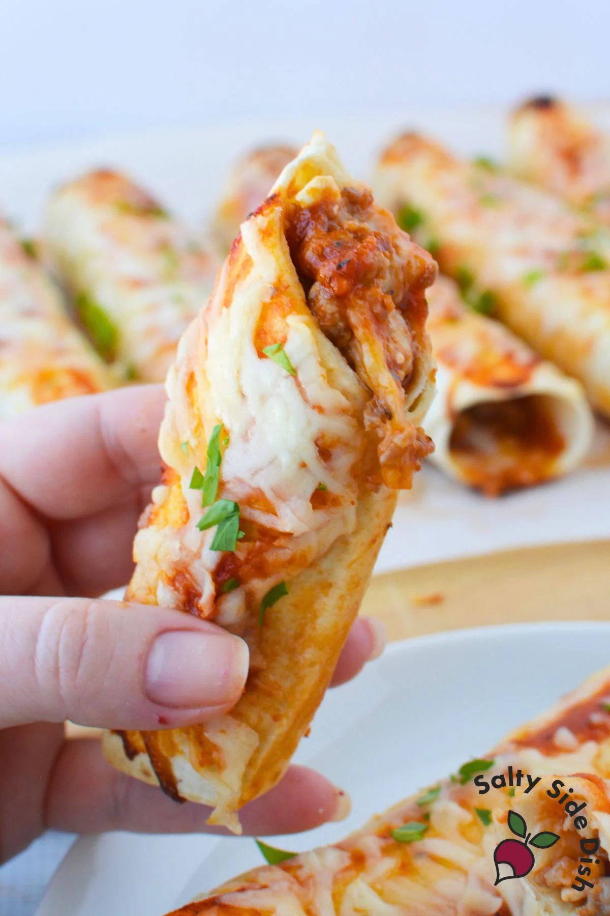 Lasagna roll with tortilla filled with Italian sausage, pasta sauce, cottage cheese, and melted mozzarella