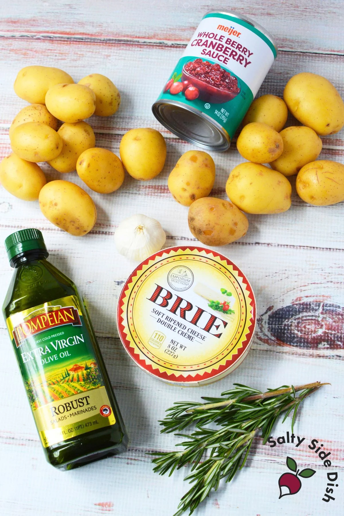 Ingredients for cranberry Brie smashed potatoes, including baby gold potatoes, whole berry cranberry sauce, Brie, olive oil, garlic, and rosemary.