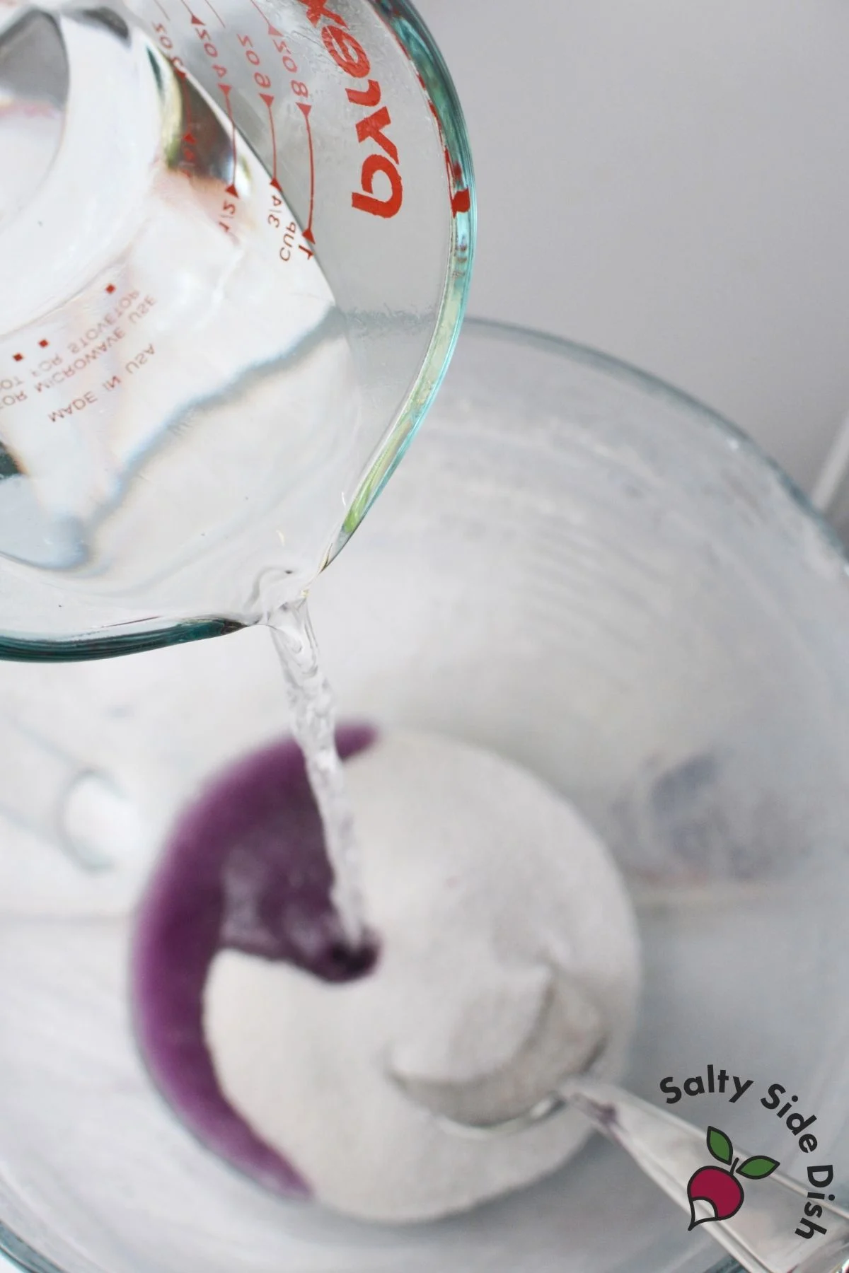 Boiling water being poured into flavored gelatin to make Jello roll ups
