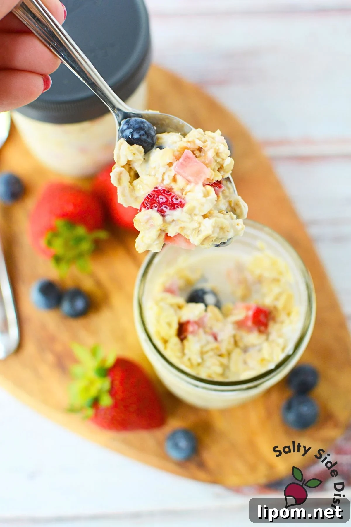 Overnight Oats Recipes: 4 Flavor Variations to Prep Ahead 8 Spoonful of creamy berry overnight oats with strawberries and blueberries above a mason jar.