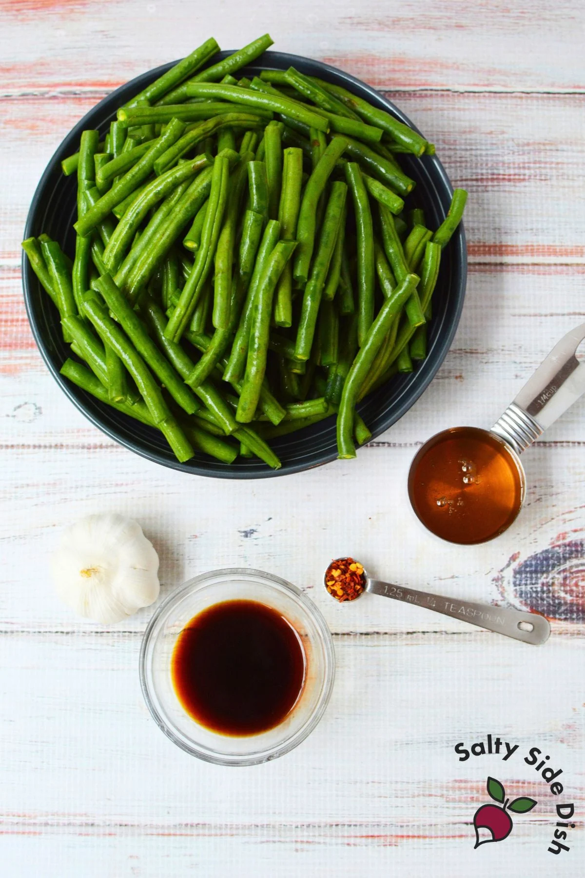 Ingredients for honey garlic green beans including fresh green beans, honey, garlic, soy sauce, and crushed red pepper flakes.