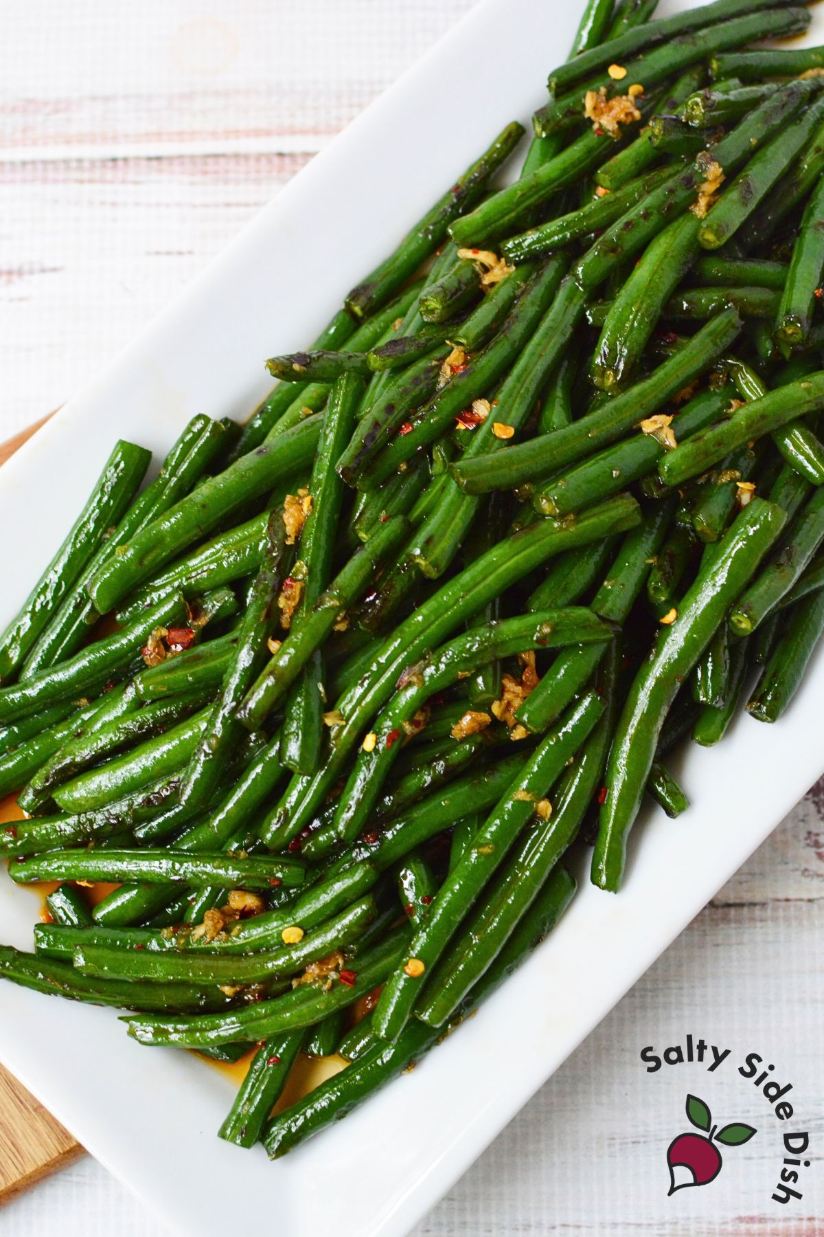 Blistered honey garlic green beans with browned edges and a glossy sauce.
