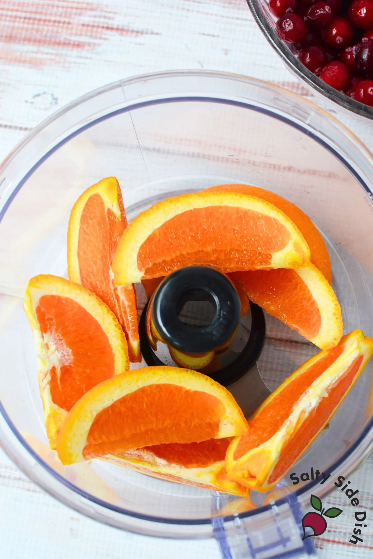 Navel orange wedges with peel in a food processor for cranberry relish